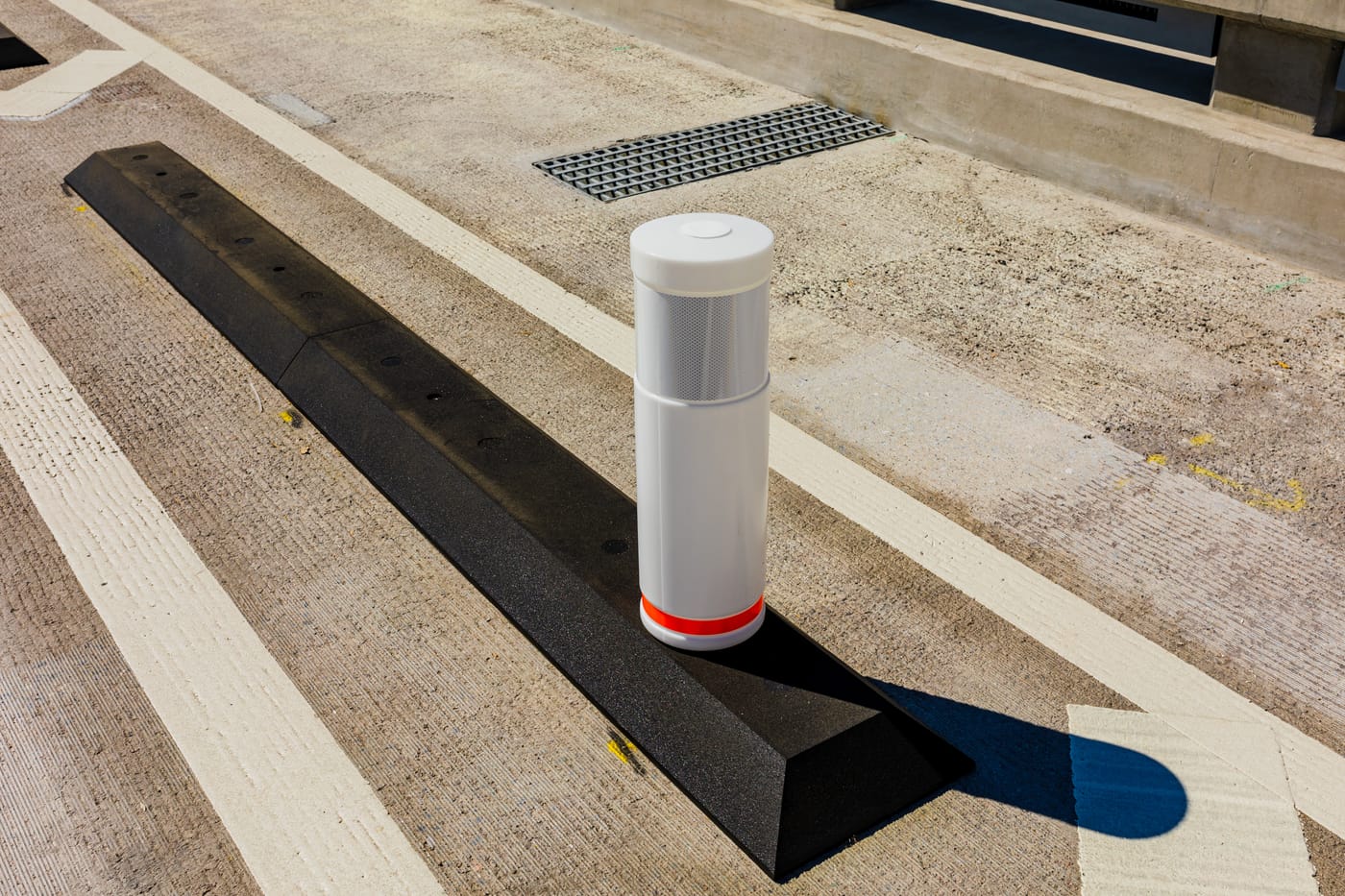 Close-up of the bespoke recycled-rubber lane divider surface-fixed to the bridge deck with a delineator post on top